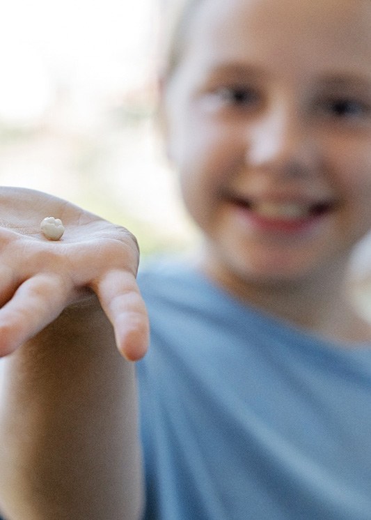 Young boy holding his extracted tooth