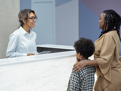 Mother and sun talking to a receptionist