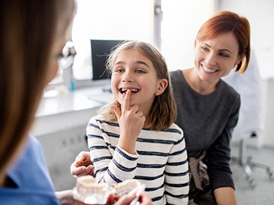 A girl showing her dentist her tooth