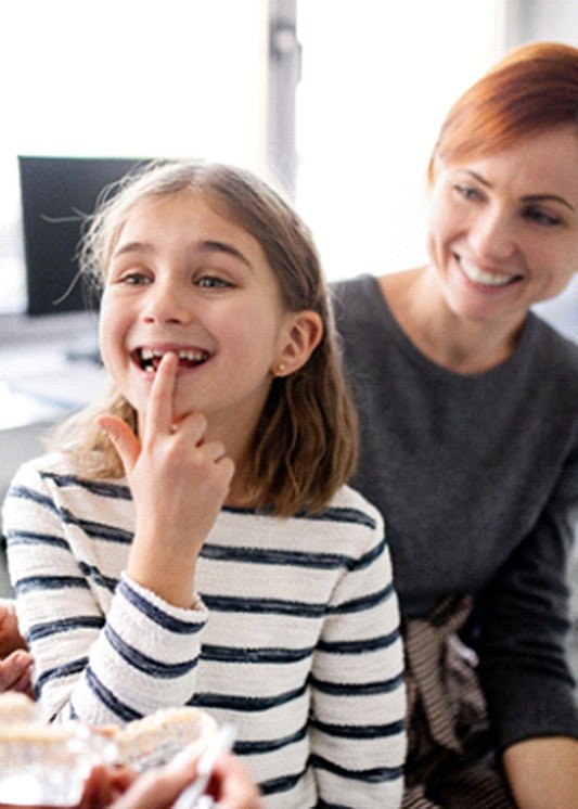 A girl pointing to her tooth at the dentist