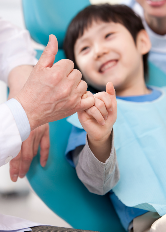 A boy giving a peace sign at the dentist