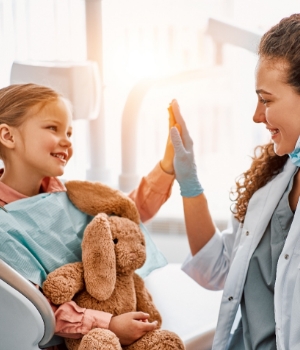 Child smiling with dentist after emergency appointment