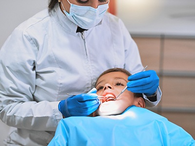A boy lying in a treatment chair awaiting dental sealants