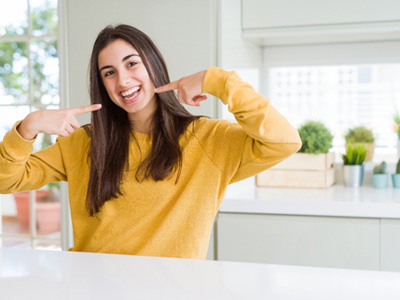 Teen pointing to her smile