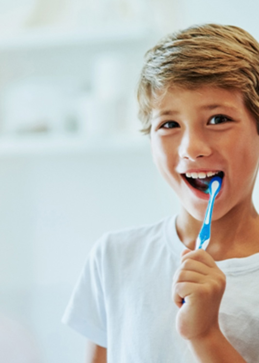 Katy child brushing teeth in mirror