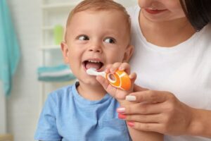 Parent helping their child brush their teeth